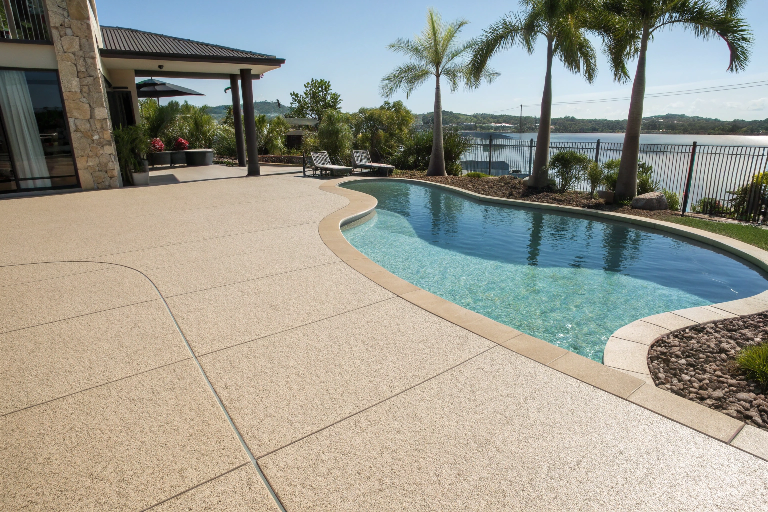 Slip-resistant pool deck epoxy applications on Sunshine Coast home showing textured surface around swimming pool for safe barefoot walking